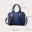 Bolsa tote estruturada azul-marinho com alças duplas, correia de ombro ajustável e chaveiro pompom decorativo