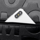Smartphone branco sobre bolsa preta de couro com zíper e textura