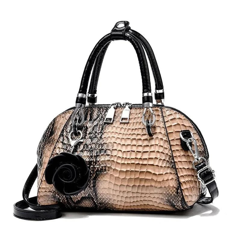 Bolsa de Mão Monarca bege e preta, textura de cobra e croco. Design semiesférico, alças pretas, charm de rosa. Elegante e sofisticada.