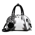 Bolsa de Mão Monarca branca e preta, textura de cobra e croco. Design semiesférico, alças pretas, charm de rosa. Elegante e sofisticada.