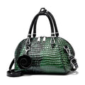 Bolsa de Mão Monarca verde-escuro, couro com textura croco brilhante. Design semiesférico, alças pretas, charm de rosa. Elegante e sofisticada.