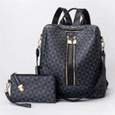 Conjunto de bolsa mochila feminina preta com estampa geométrica de triângulos e detalhes dourados, acompanhada de uma carteira combinando, em fundo neutro.