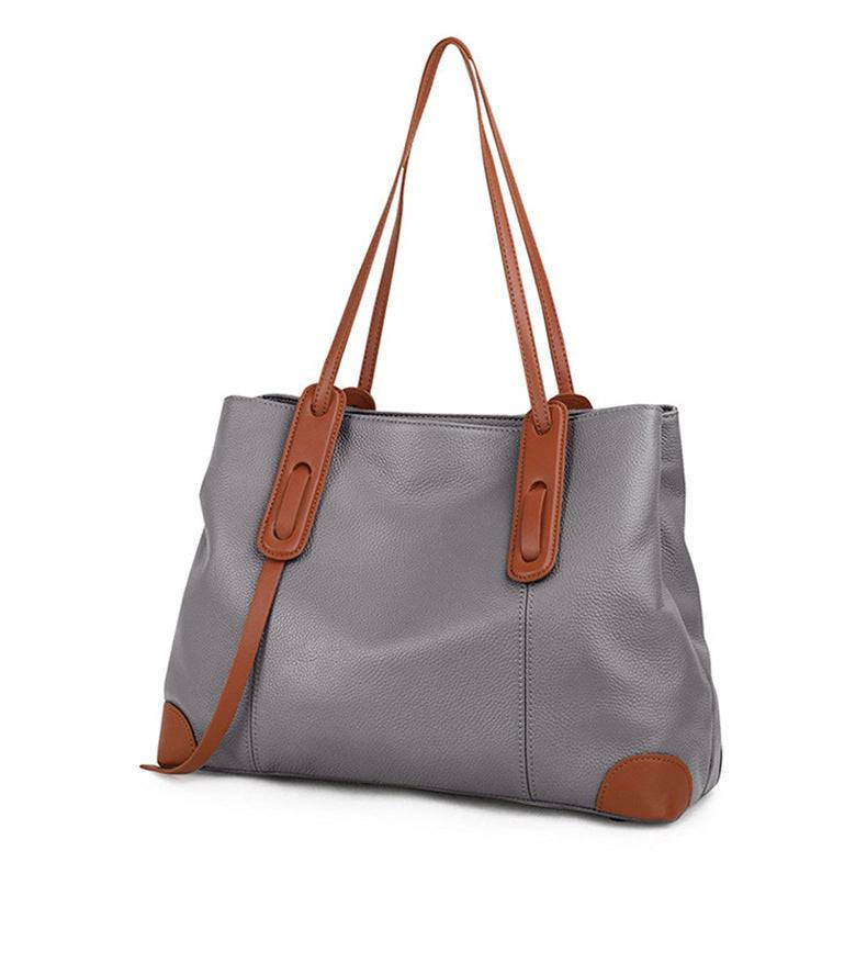 Bolsa de ombro feminina em couro legítimo, na cor cinza com alças e detalhes em couro marrom.