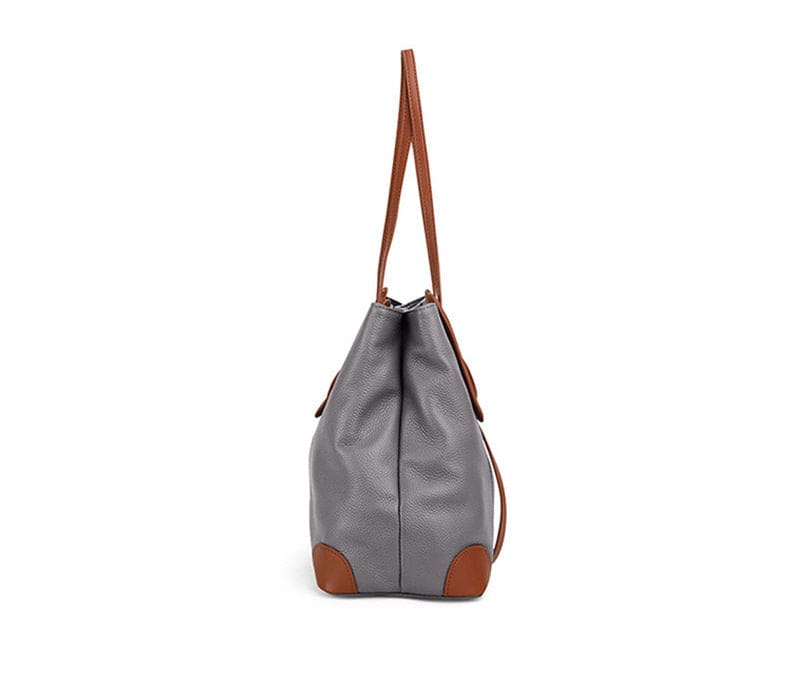 Lateral da bolsa de ombro feminina em couro legítimo cinza, com alças marrons longas e reforços em couro.