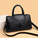 Bolsa satchel preta com textura croco, alças estruturadas e alça de ombro