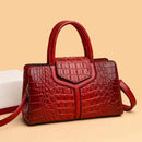 Bolsa satchel vermelha com textura de couro croco e alças estruturadas