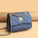 Bolsa satchel pequena azul marinho matelassê com fecho de torção dourado e alça de corrente metálica, estilo elegante e sofisticado.
