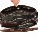 Bolsa feminina de couro marrom aberta com compartimentos internos e bolsos com zíper