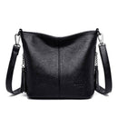 Bolsa tiracolo de couro preta com textura granulada e alças ajustáveis