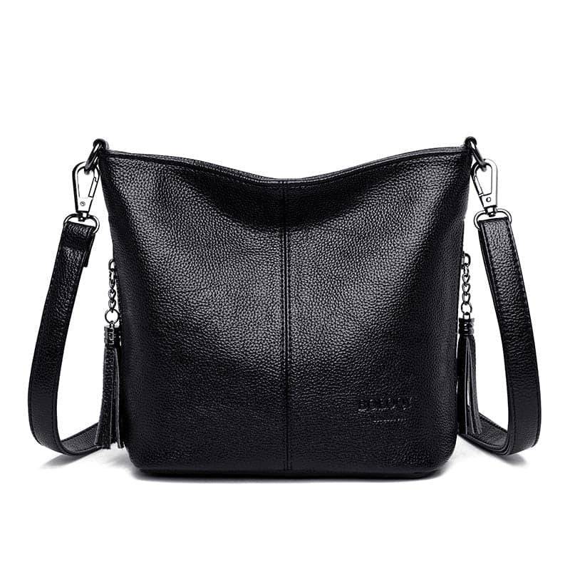 Bolsa tiracolo de couro feminina Ladies preta com acabamento granulado, design macio e alça transversal ajustável com detalhes de corrente e borlas, em vista frontal.