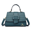 Bolsa Tiracolo Feminina Couro Legítimo Lavish azul-petróleo. Textura croco na aba, fecho de fivela e ferragens douradas. Elegante e sofisticada.