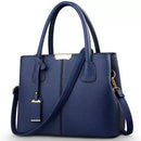 Bolsa tote azul marinho com alças duplas e alça transversal, detalhe frontal metálico