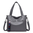 Bolsa tote cinza com alças de ombro, bolsos frontais e chaveiro colorido com texto LOVE