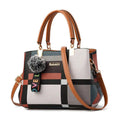 Bolsa tote feminina estampada de couro sintético Kouy com padrão xadrez multicolorido e alças marrons, exibindo chaveiro de pompom e alça transversal para versatilidade.