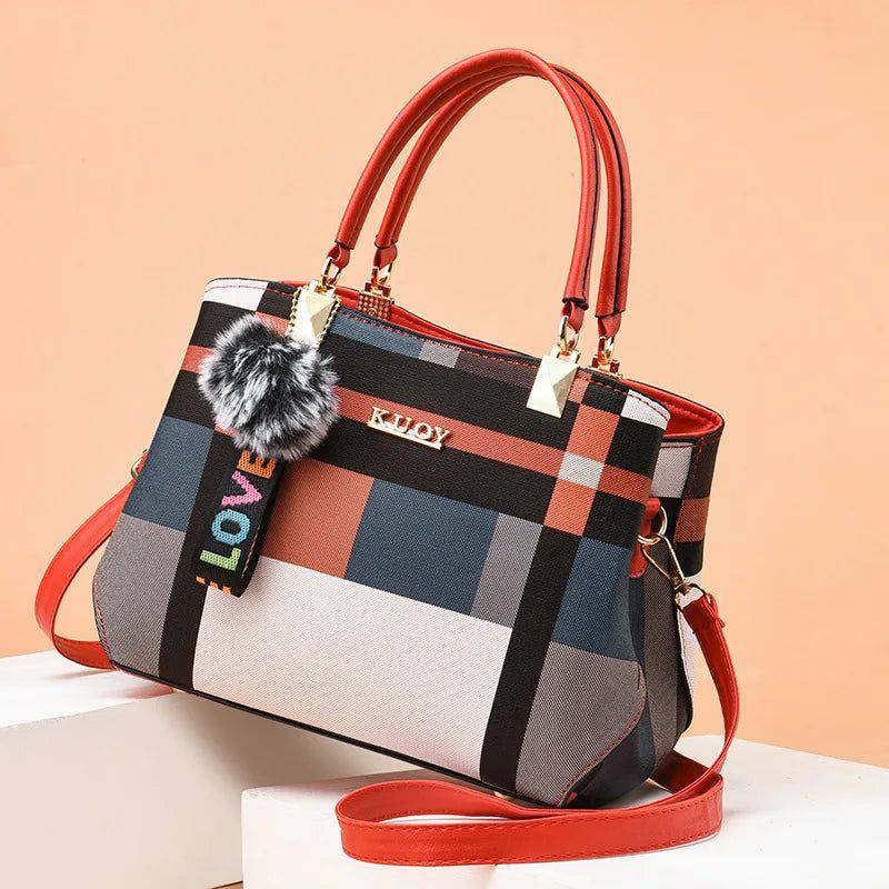 Bolsa tote feminina estampada de couro sintético Kouy com padrão xadrez multicolorido e alças vermelhas, exibindo chaveiro de pompom e alça transversal removível.