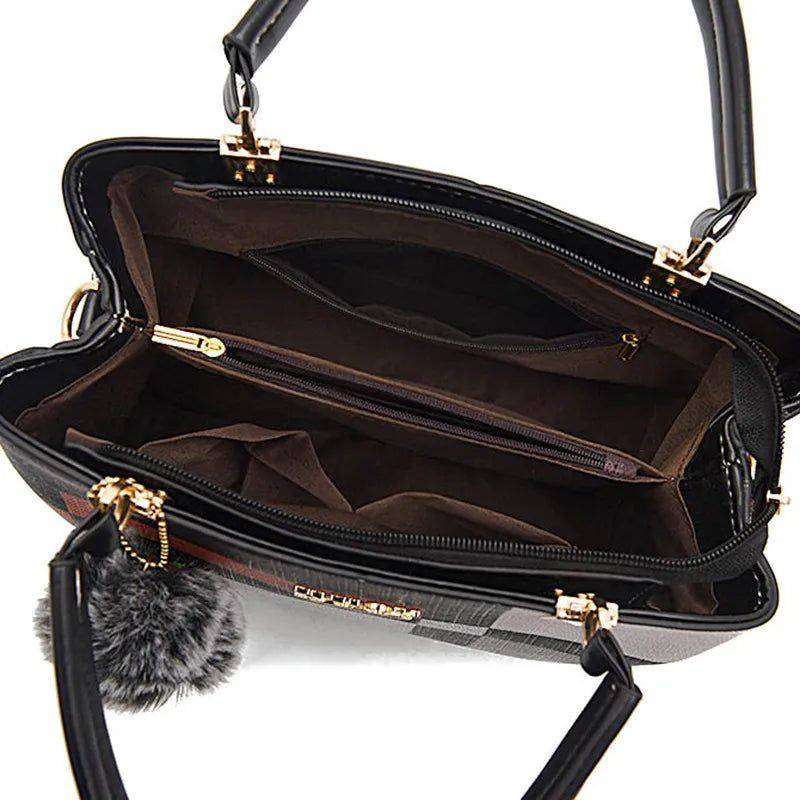 Visão superior do interior da bolsa tote Kouy estampada, revelando forro escuro com múltiplos compartimentos e bolsos com zíper para organização, com chaveiro de pompom visível.