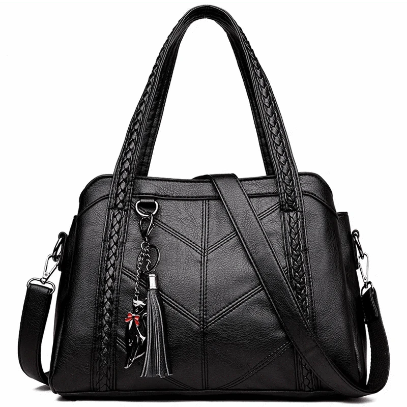 Bolsa Tote Estruturada preta. Detalhes de costura em V, alças trançadas e tassel com charm. Alça adicional. Elegante e espaçosa.