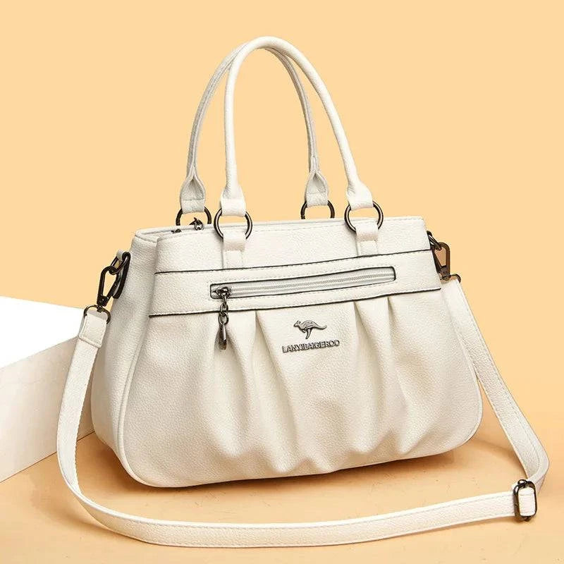 Bolsa Tote Estruturada Feminina Couro Radiance branca. Zíper frontal, pregas, ferragens prateadas. Elegante e funcional para o dia a dia.