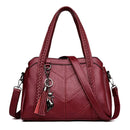 Bolsa tote estruturada em couro sintético vinho com costura em chevron e alças trançadas, estilo elegante e alça de ombro ajustável.