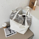 Bolsa tote branca com rebites metálicos em padrão grid