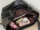Bolsa tote preta de couro aberta, mostrando interior com bolsos e itens pessoais organizados