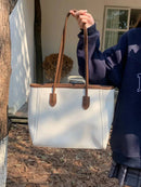 Bolsa tote branca de couro com alças marrom, design minimalista e costuras verticais