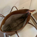 Bolsa tote de couro marrom aberta mostrando interior com bolso de zíper
