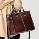 Bolsa tote couro marrom escuro com alças duplas, costura branca e alça transversal