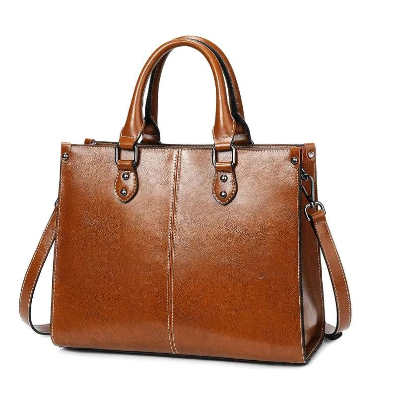Bolsa Tote Feminina Couro Legítimo Velvet marrom. Couro com acabamento brilhante, costura branca, alças e ferragens metálicas. Elegante e estruturada.