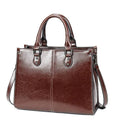 Bolsa Tote Feminina Couro Legítimo Velvet marrom-escuro. Acabamento brilhante, costura branca, alças de mão e transversal. Elegante e estruturada.