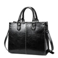 Bolsa Tote Feminina Couro Legítimo Velvet preta. Acabamento brilhante, costura branca, alças duplas e alça removível. Elegante e estruturada.