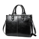 Bolsa tote feminina de couro preto com alças duplas, costura branca e alça transversal ajustável