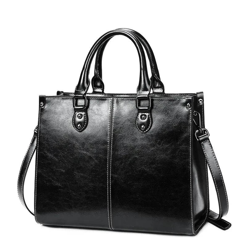 Bolsa Tote Feminina Couro Legítimo Velvet preta. Acabamento brilhante, costura branca, alças duplas e alça removível. Elegante e estruturada.