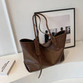 Bolsa Tote Feminina em Couro Marrom com alça longa, vista completa em fundo neutro, ideal para composições sofisticadas.