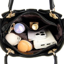 Bolsa tote preta aberta mostrando interior organizado com celular, power bank e cosméticos