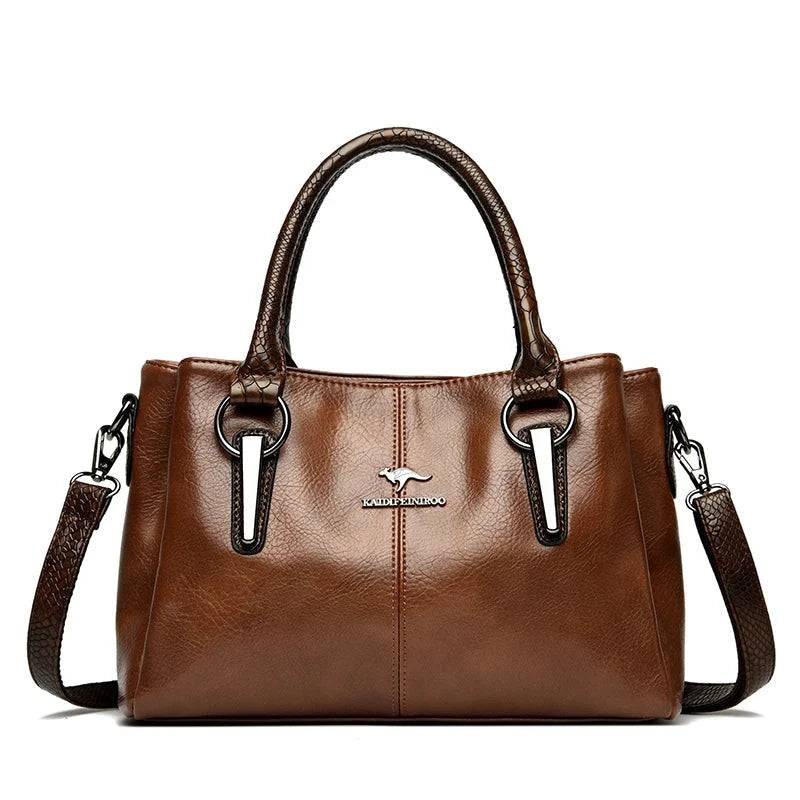 Bolsa Tote Feminina Couro Sublime marrom, acabamento brilhante, alças duplas. Logo metálico e ferragens prateadas. Elegante e versátil para o dia a dia.