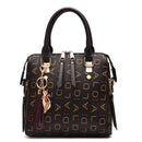Bolsa tote estruturada preta com padrão monograma dourado, alças pretas e chaveiro gato com borla