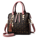 Bolsa tote estruturada com estampa de monograma dourado, alças rosa e correia removível, com charm de borla.