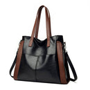 Bolsa tote preta com laterais marrons, alça transversal destacável e alças de ombro.