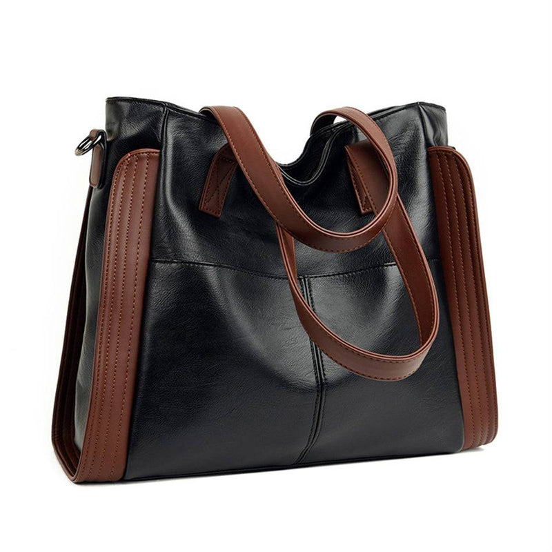 Bolsa tote feminina de couro sintético Sofia preta com detalhes marrons nas laterais e alças, exibida em fundo branco para e-commerce, destacando seu design espaçoso.