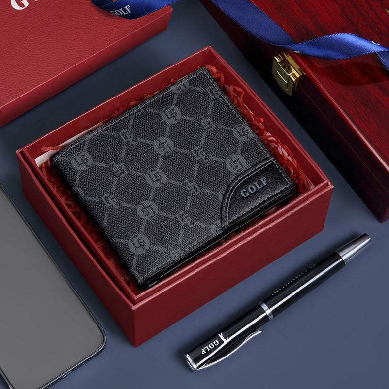 Carteira masculina Slim Golf preta com estampa de monograma e detalhes em pesponto, apresentada em uma elegante caixa de presente vermelha. Acompanha caneta e fita azuis da marca Golf, sugerindo um presente de luxo e estilo.