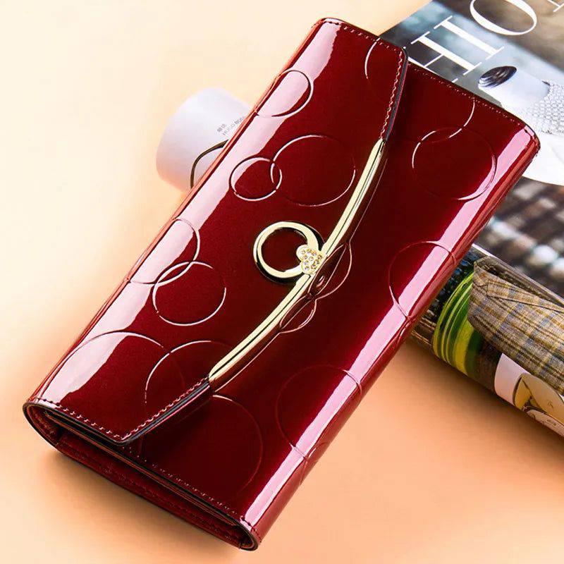 Carteira feminina de couro genuíno de luxo vinho com acabamento brilhante, design em relevo de formas orgânicas e fecho dourado com detalhe de strass.
