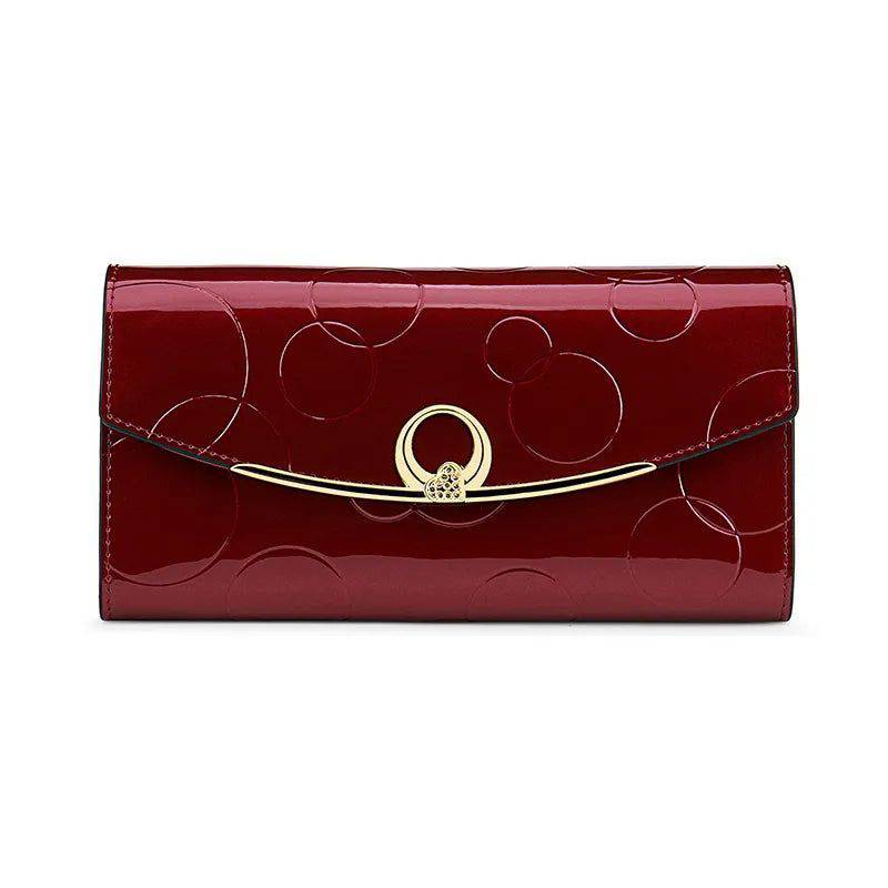 Carteira feminina de couro genuíno de luxo vinho com acabamento brilhante e design em relevo de círculos, fecho dourado com detalhe de strass, em vista frontal isolada.