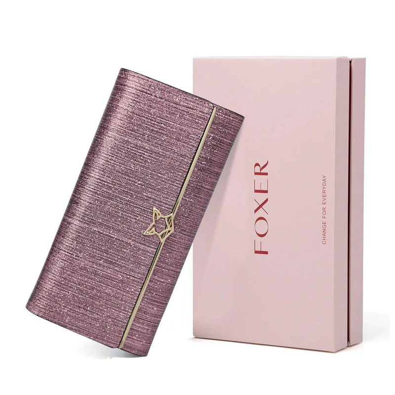 Carteira feminina de couro luxuosa rosa metálico com brilho e fecho de estrela dourado, exibida inclinada ao lado de sua caixa de presente rosa da marca "FOXER".