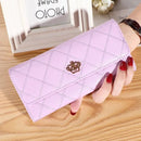 Carteira quilted rosa claro com fecho em coroa dourada, segurada em mão com unhas vermelhas