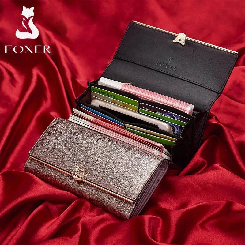 Carteira feminina de couro luxuosa rosa metálico aberta, exibindo múltiplos compartimentos com cartões e dinheiro organizados, sobre um elegante fundo de cetim vermelho.