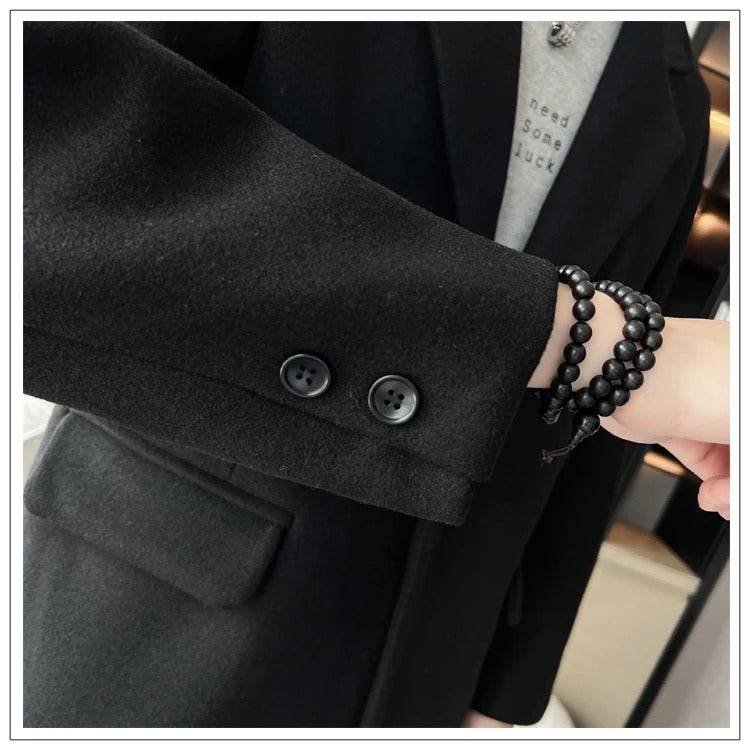 Manga do sobretudo masculino preto com dois botões decorativos. Estilo minimalista e elegante para o inverno.