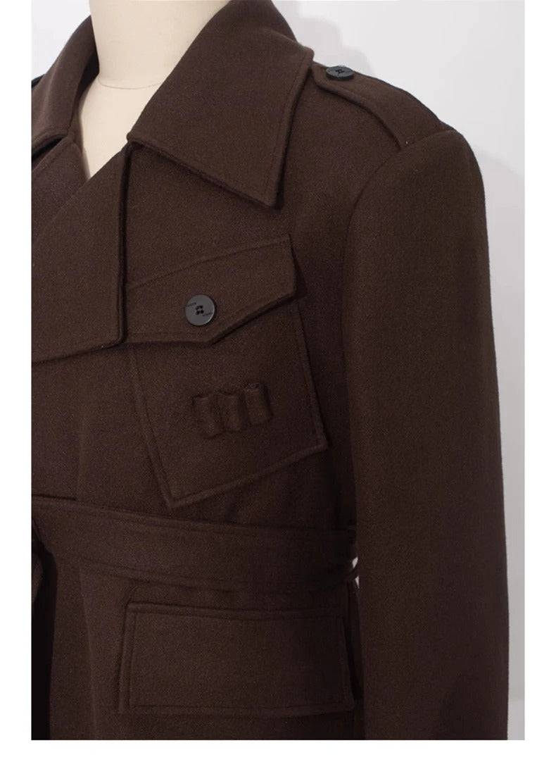 Detalhe do bolso e lapela do sobretudo masculino longo de lã batida, com botão e acabamento refinado.