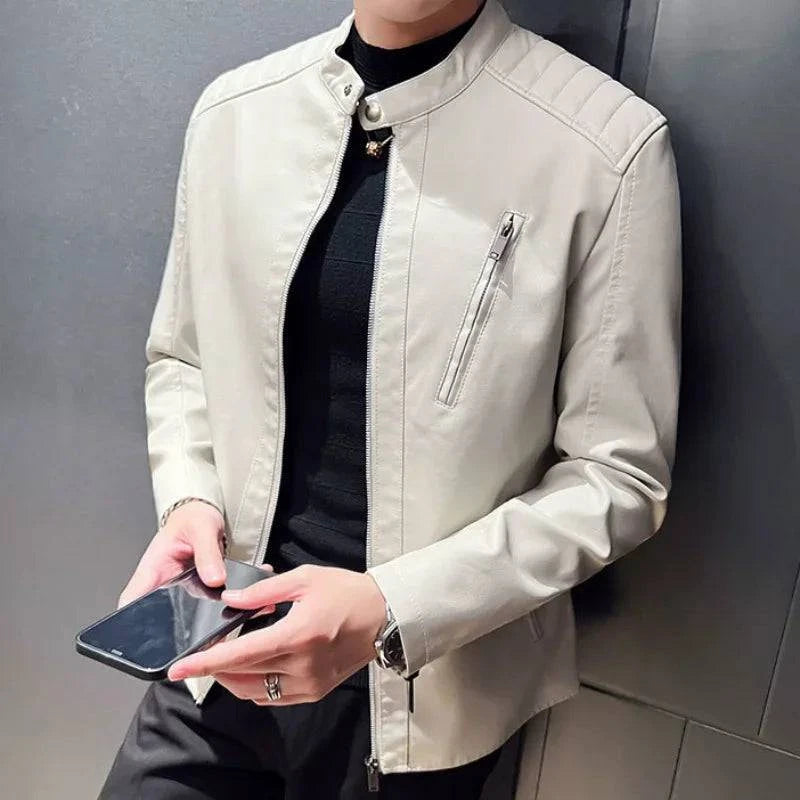 Homem usando jaqueta biker slim de couro sintético bege com gola mandarim, segurando um celular. Estilo sofisticado e minimalista, ideal para o estilo de vida contemporâneo em Embu das Artes.