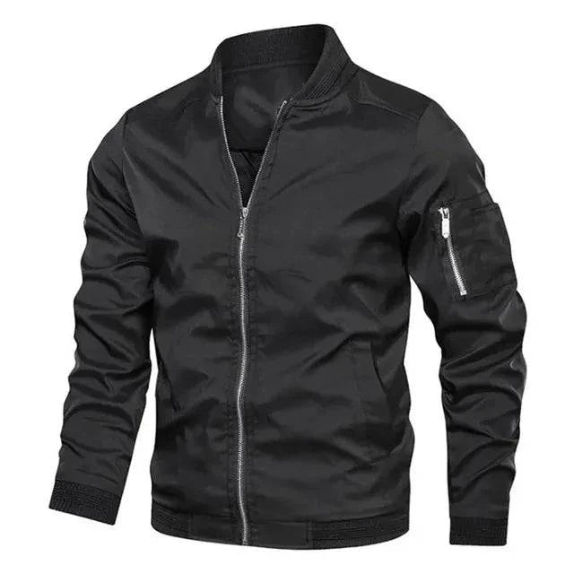 Jaqueta bomber masculina preta em manequim, zíper prateado, bolsos laterais, punhos e barra canelados pretos. Clássico essencial e sofisticado.